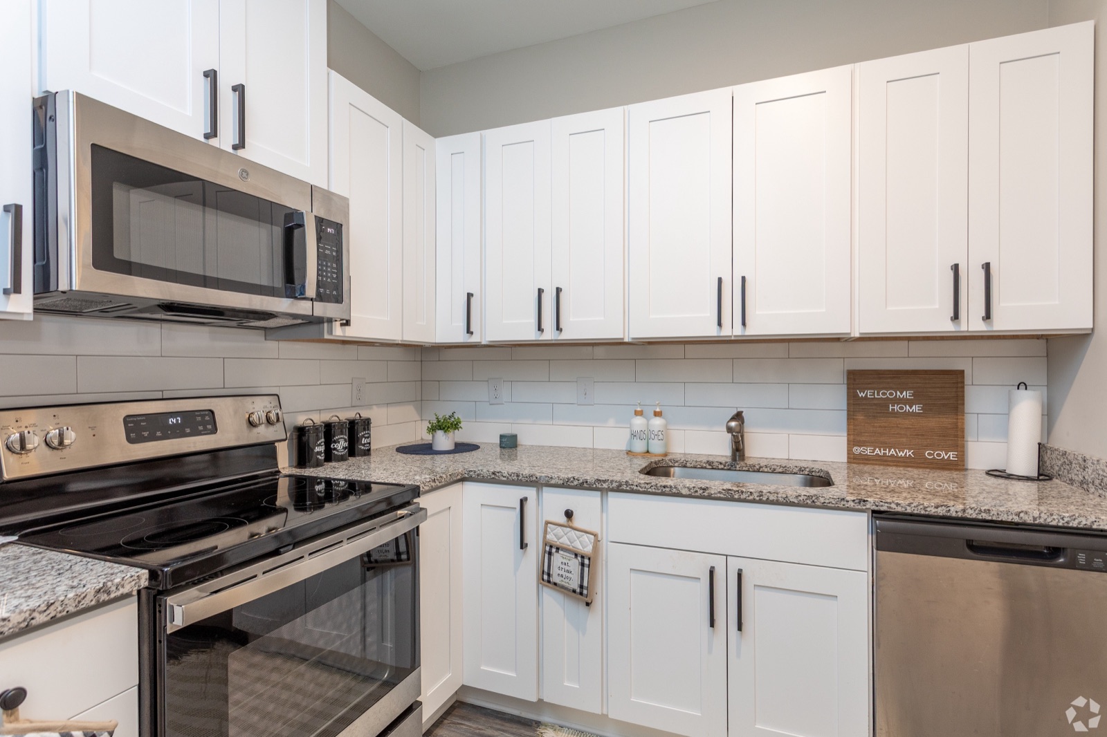 Kitchen with white cabinets, granite counters and stainless appliances